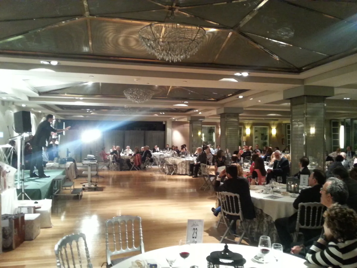 Mago actuando en el escenario de un gran salón durante una cena de empresa